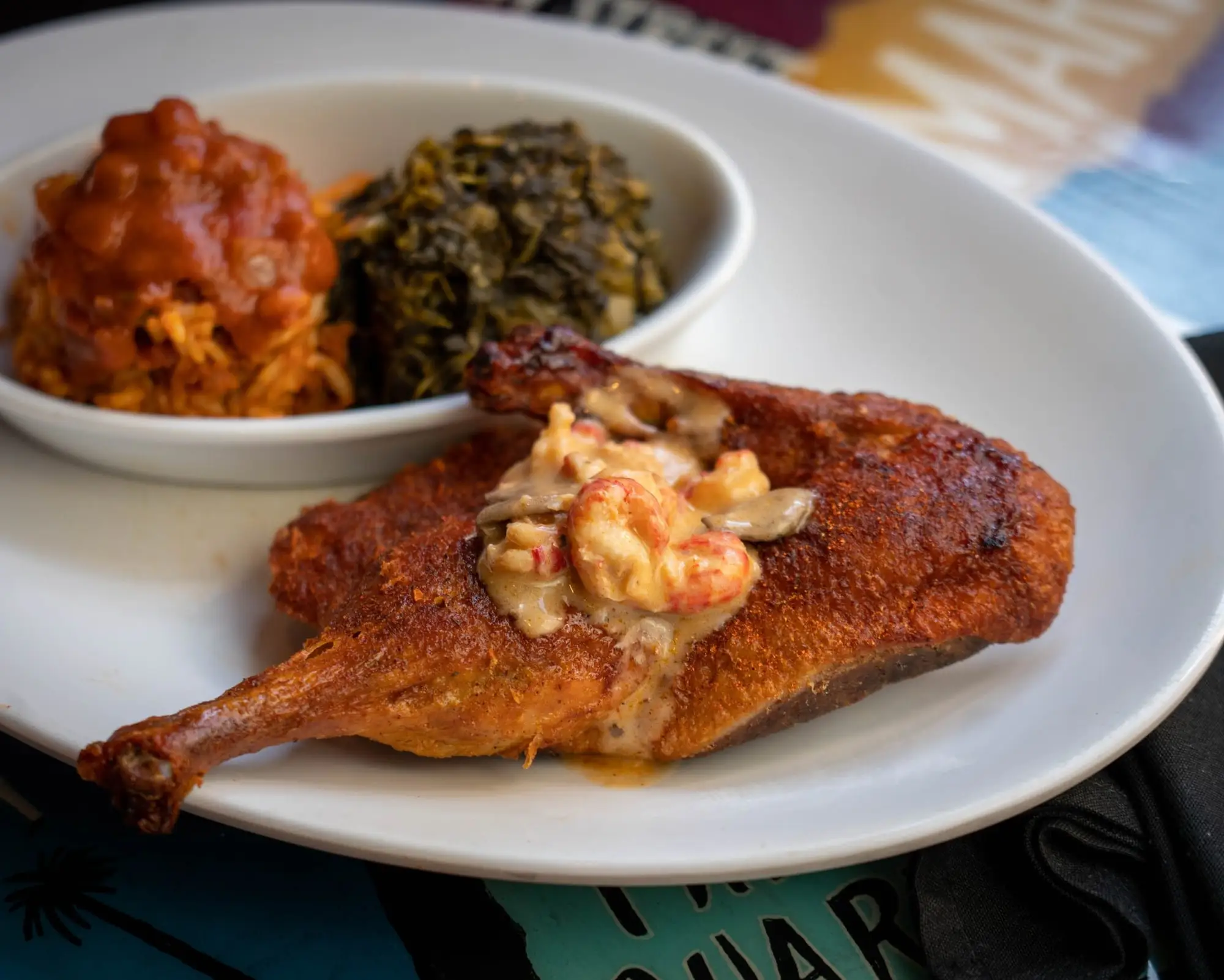 Blackened bayou duck topped with crawfish cream, with jambalaya and mustard greens