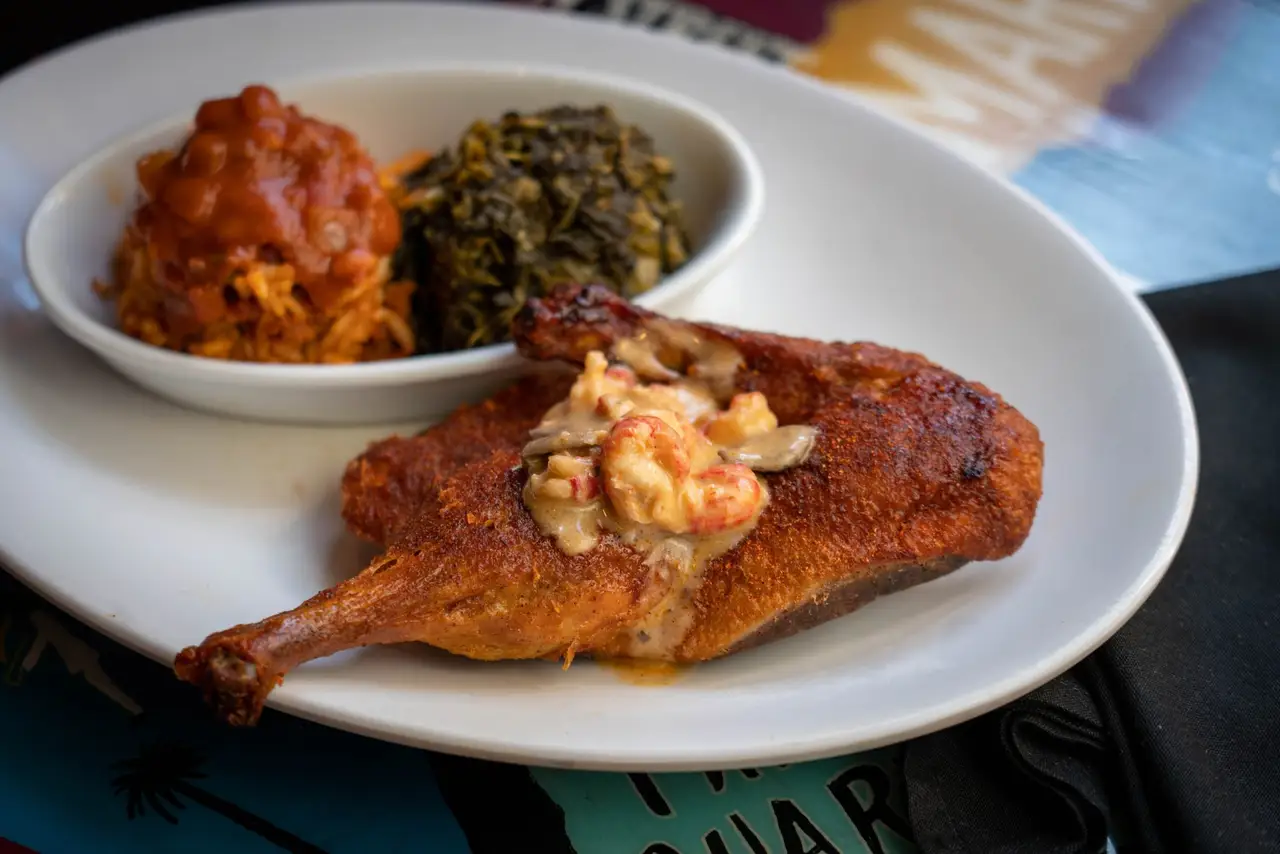 Blackened bayou duck topped with crawfish cream, with jambalaya and mustard greens