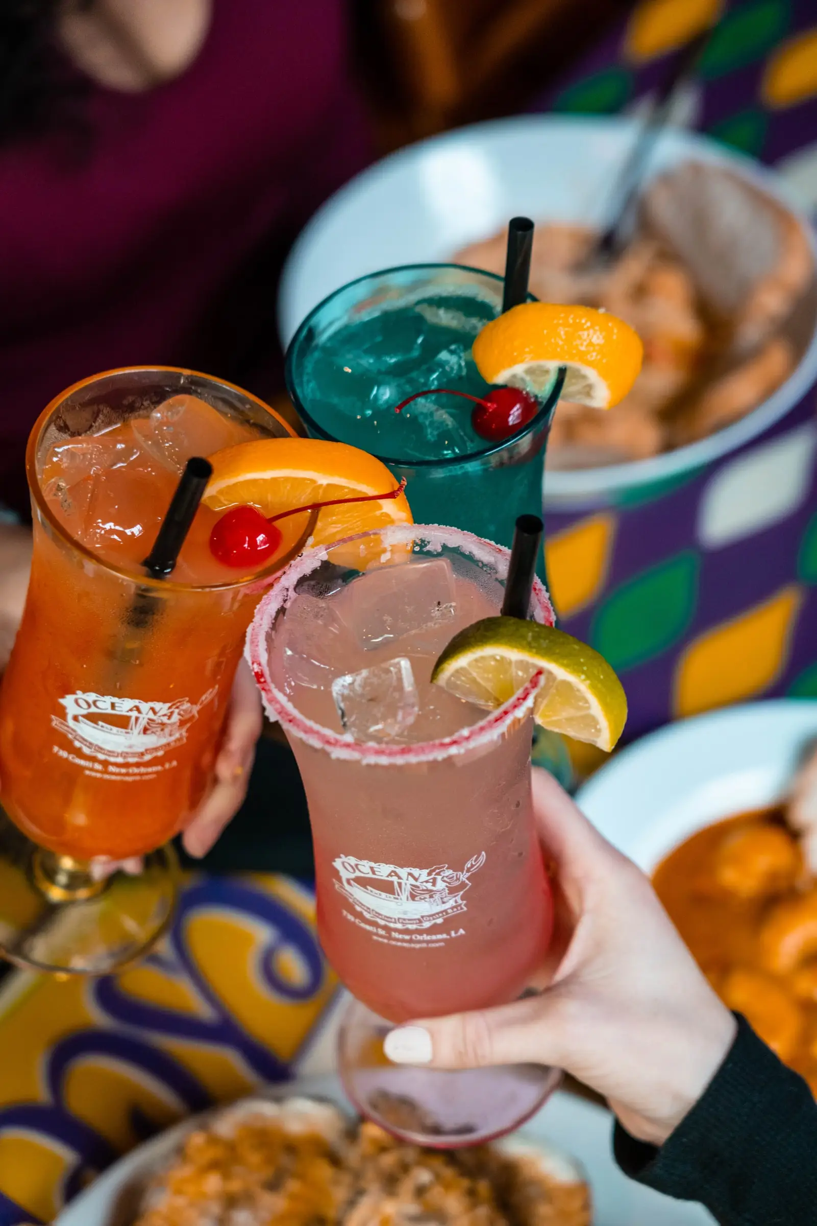 Two guests clinking Oceana cocktails in branded glasses