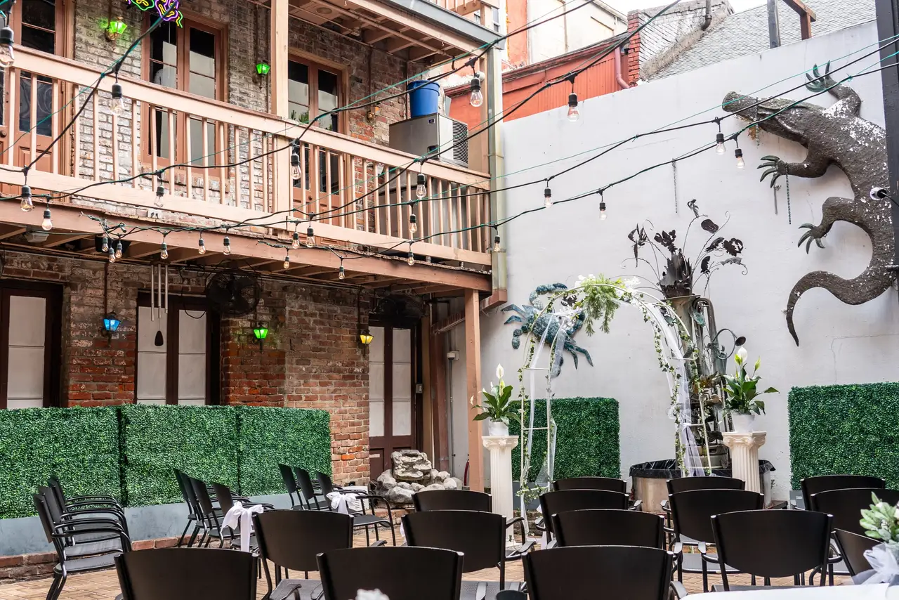 Oceana’s courtyard set for a ceremony: chairs facing a floral arch and fountain beneath the balconies