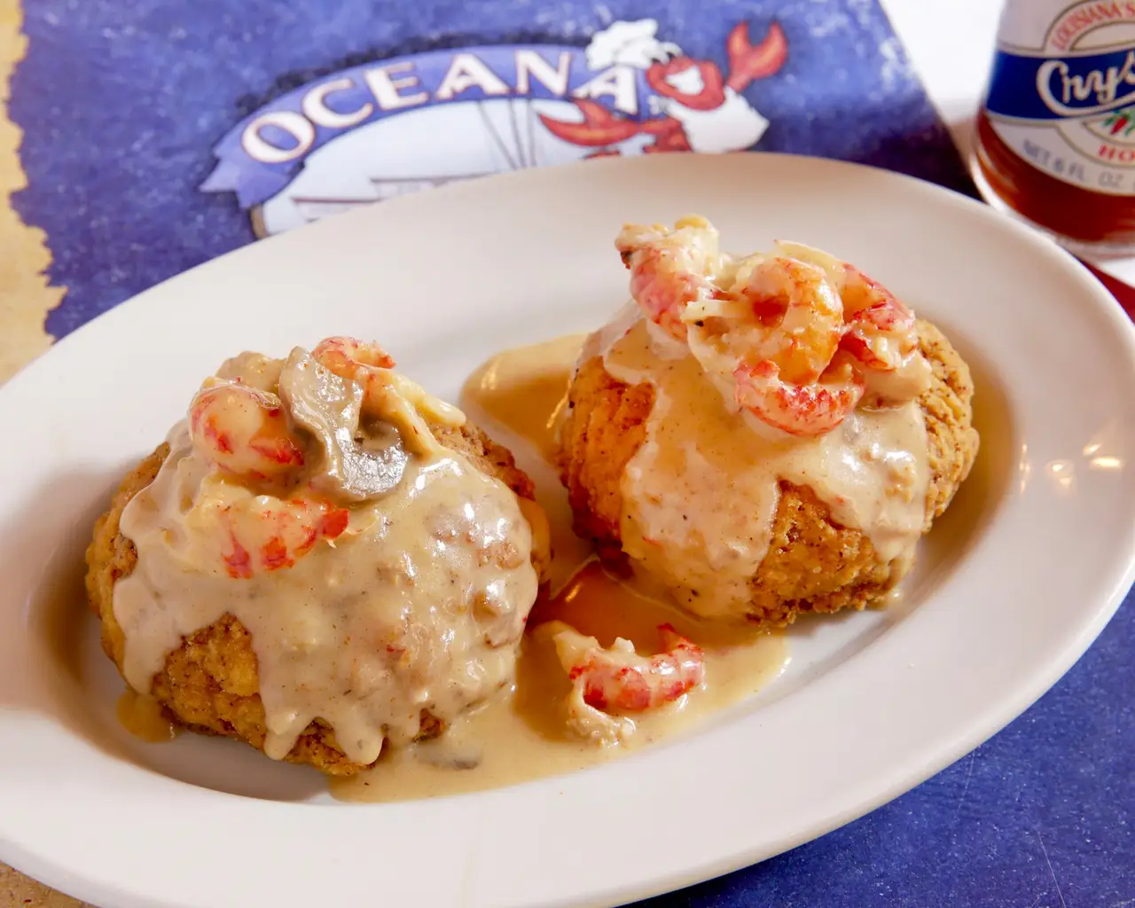Two Louisiana crabmeat cakes topped with crawfish mushroom cream sauce