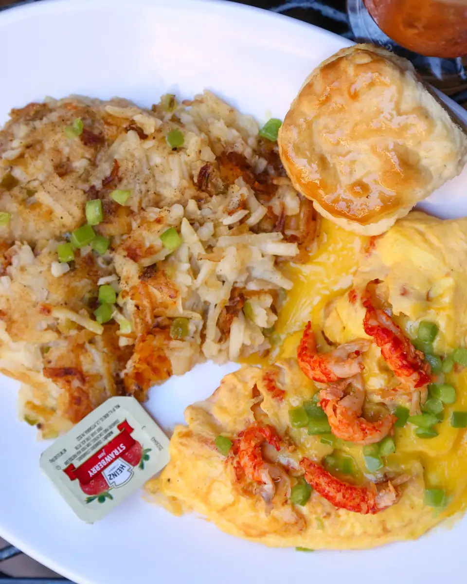 Crawfish omelette topped with hollandaise, with hash browns and a biscuit
