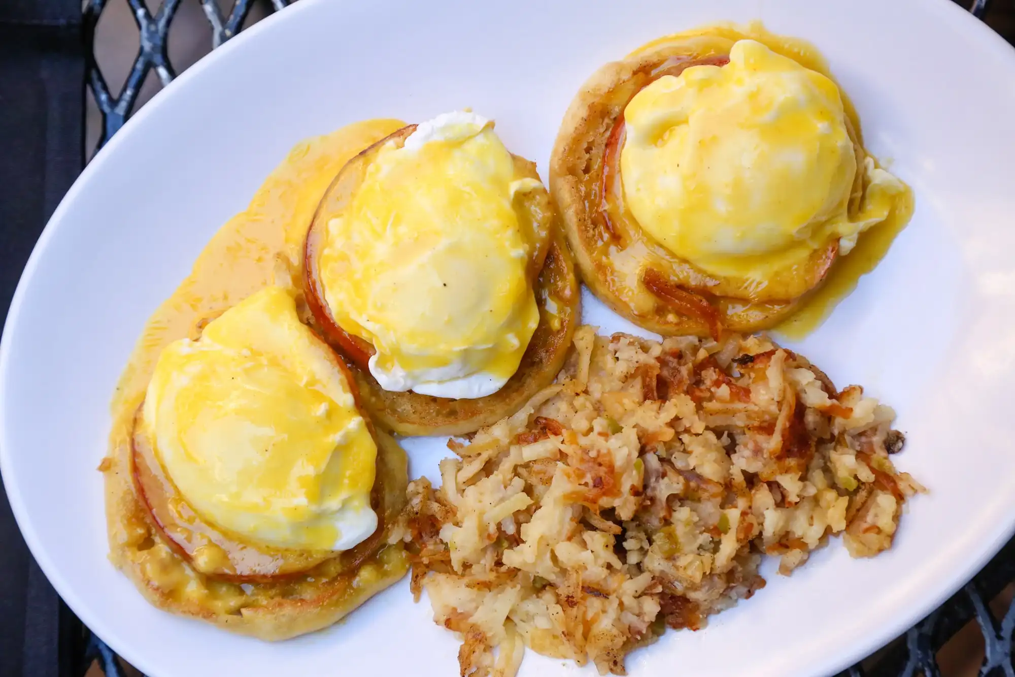 Eggs Benedict on English muffins with hollandaise and crispy hash browns