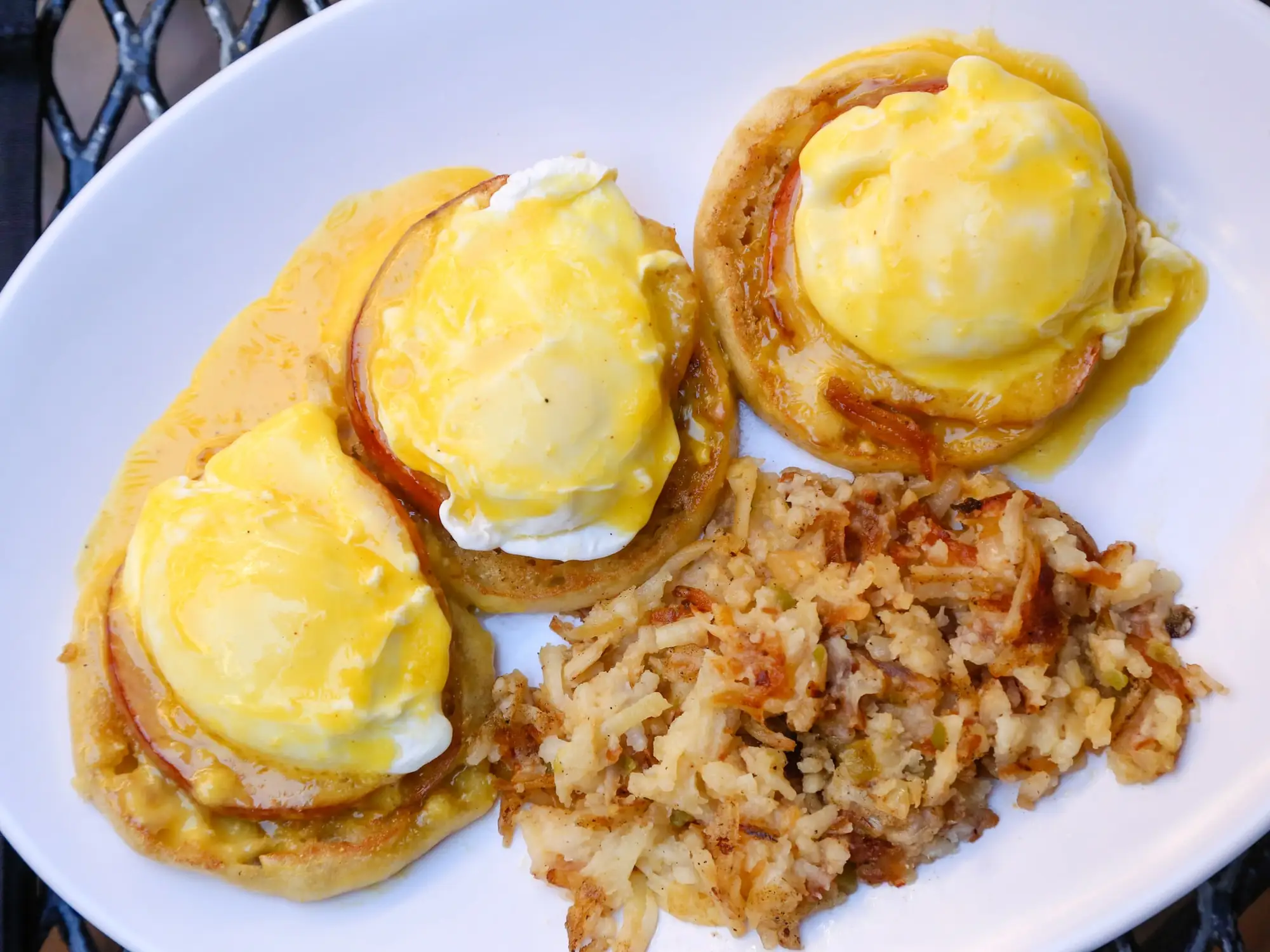 Eggs Benedict on English muffins with hollandaise and crispy hash browns