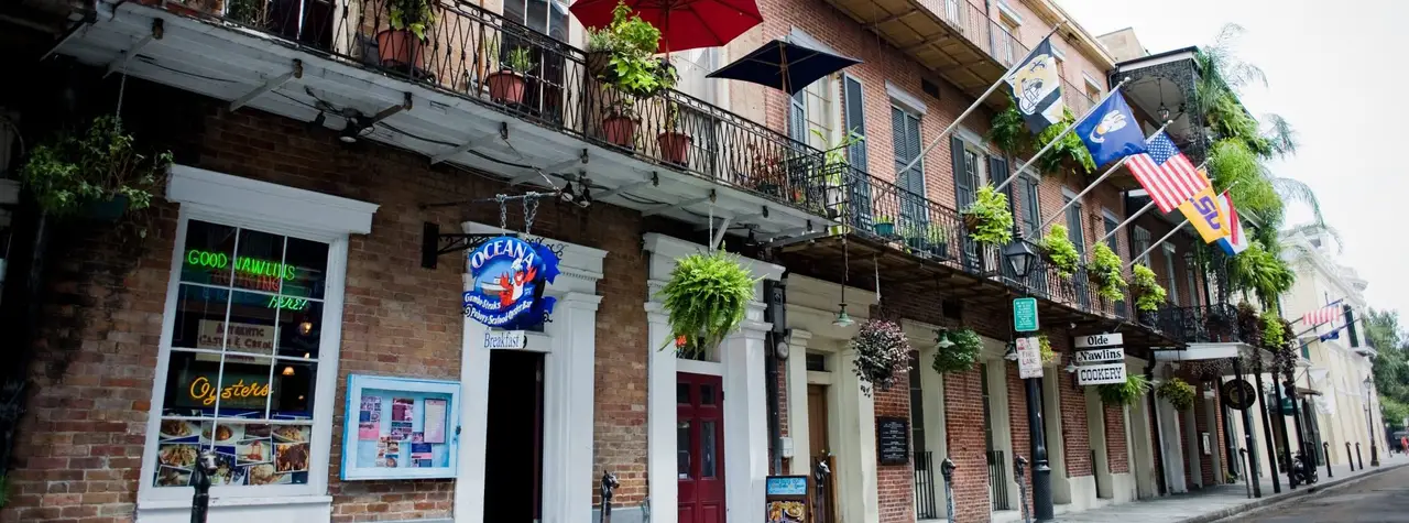Oceana Grill on Conti Street: a brick French Quarter building with iron balconies, hanging ferns and the Oceana sign over the door