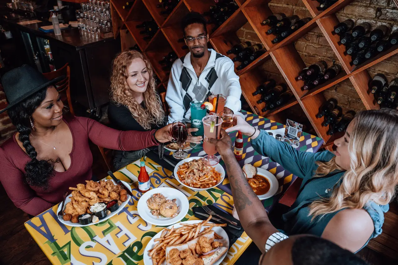 Friends raising their drinks over a table full of seafood at Oceana Grill