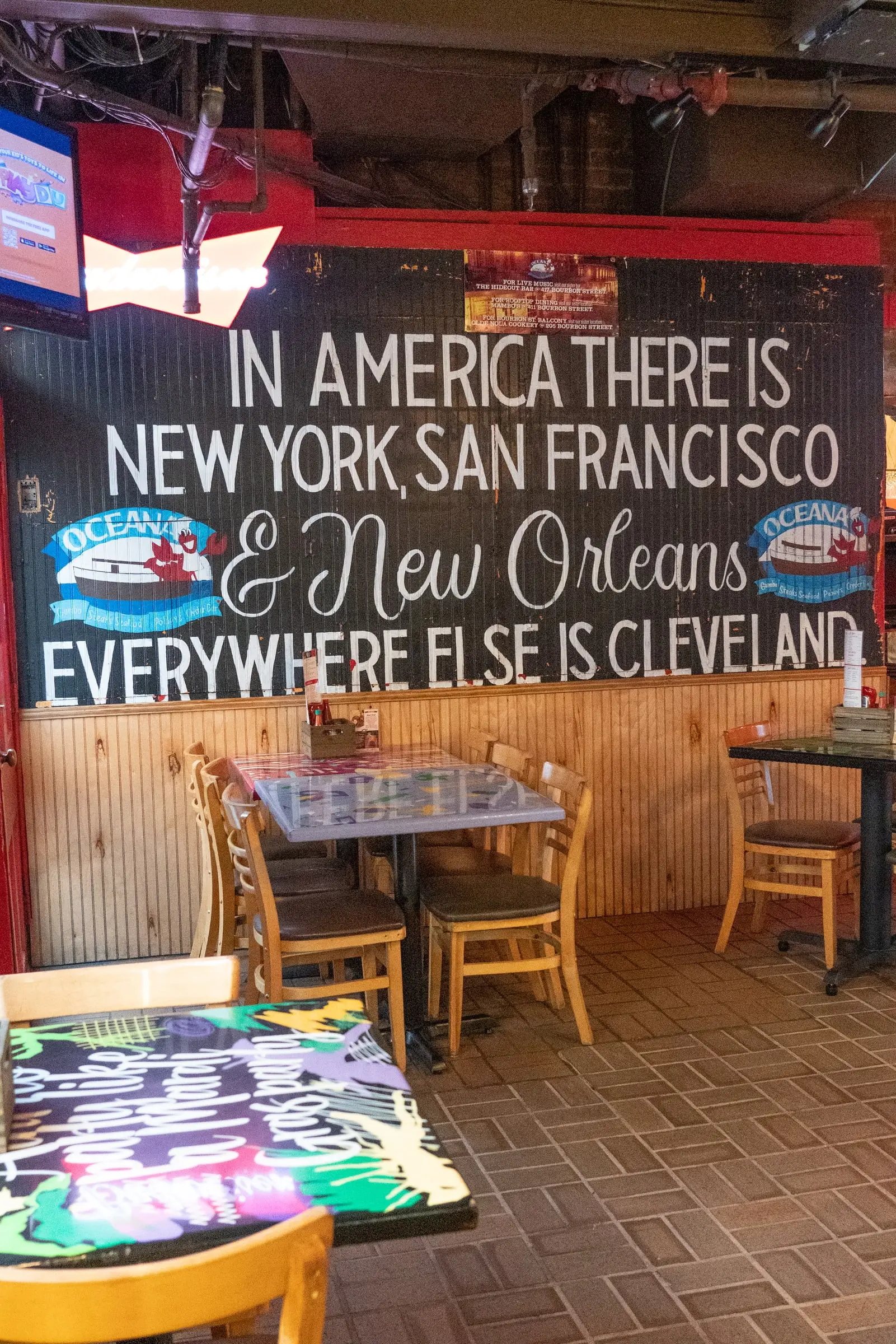 A chalkboard wall reading “In America there is New York, San Francisco & New Orleans” in Oceana’s Cookery Dining Room