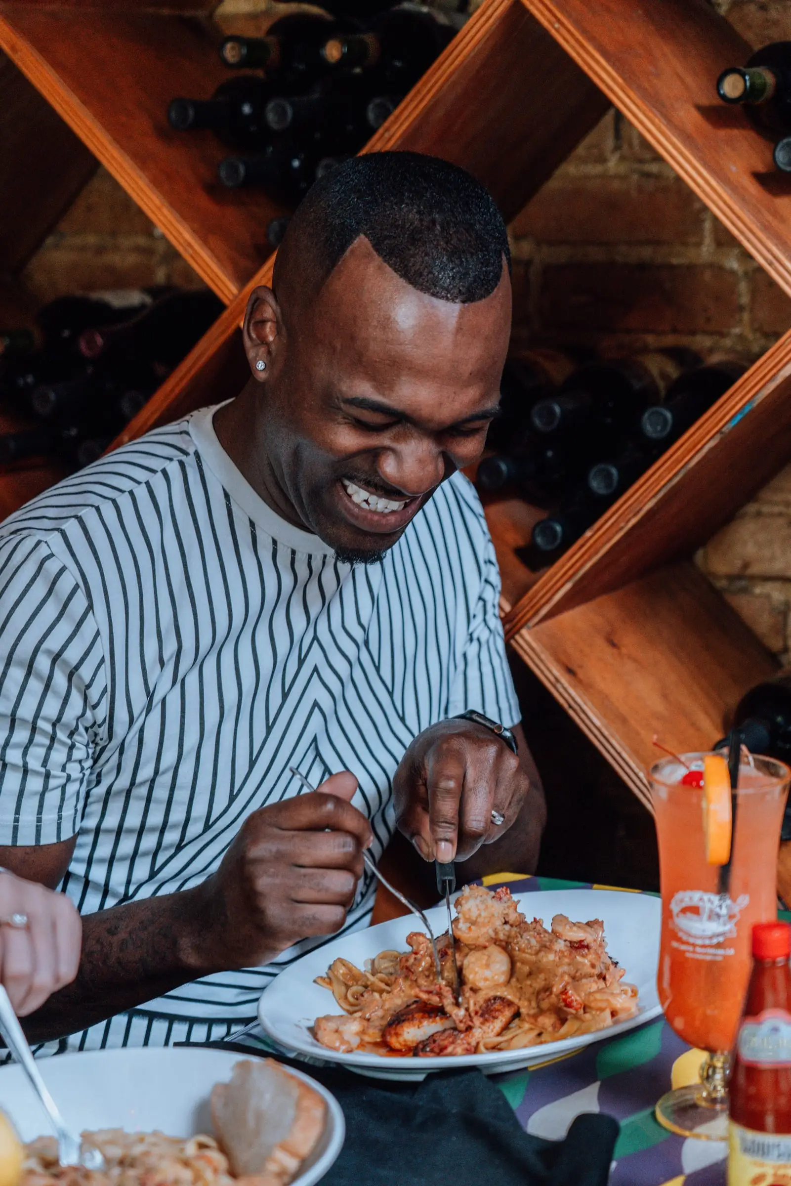 A guest laughing over a plate of seafood at Oceana Grill