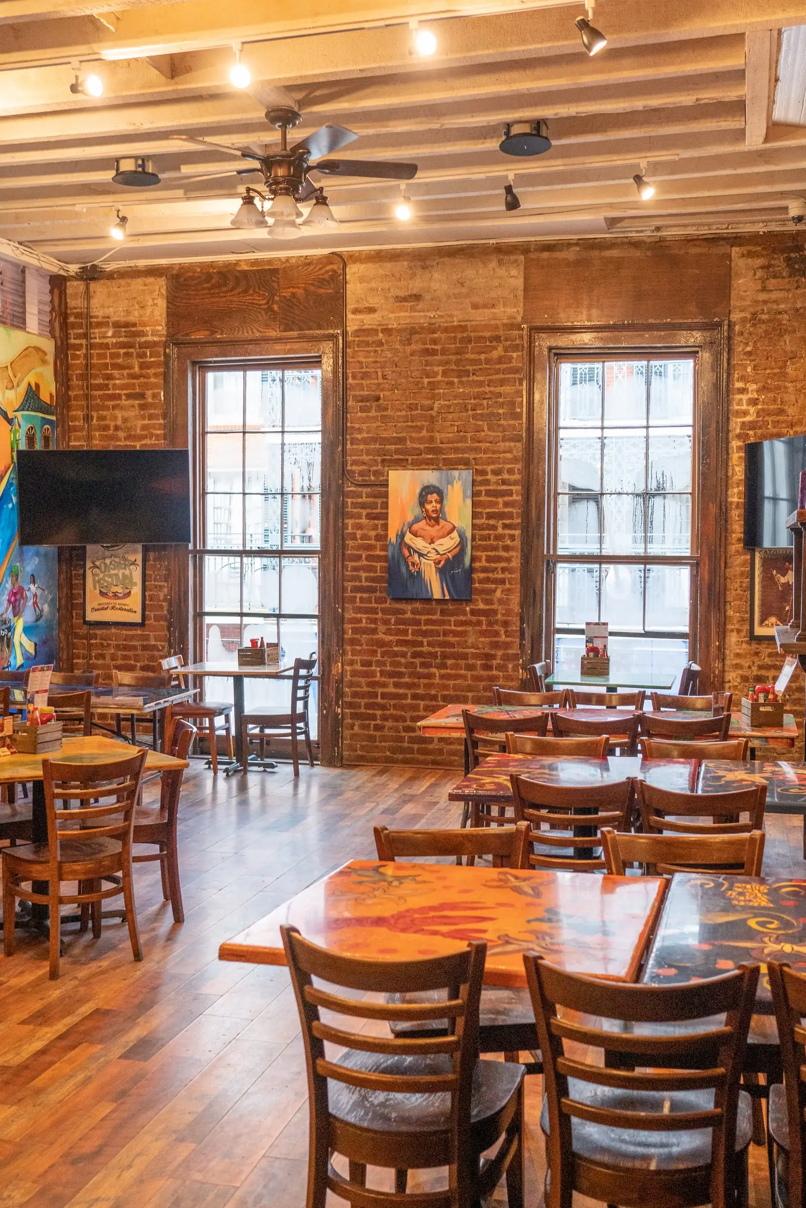 Tall windows and brick walls around the tables of the La Bohème Room