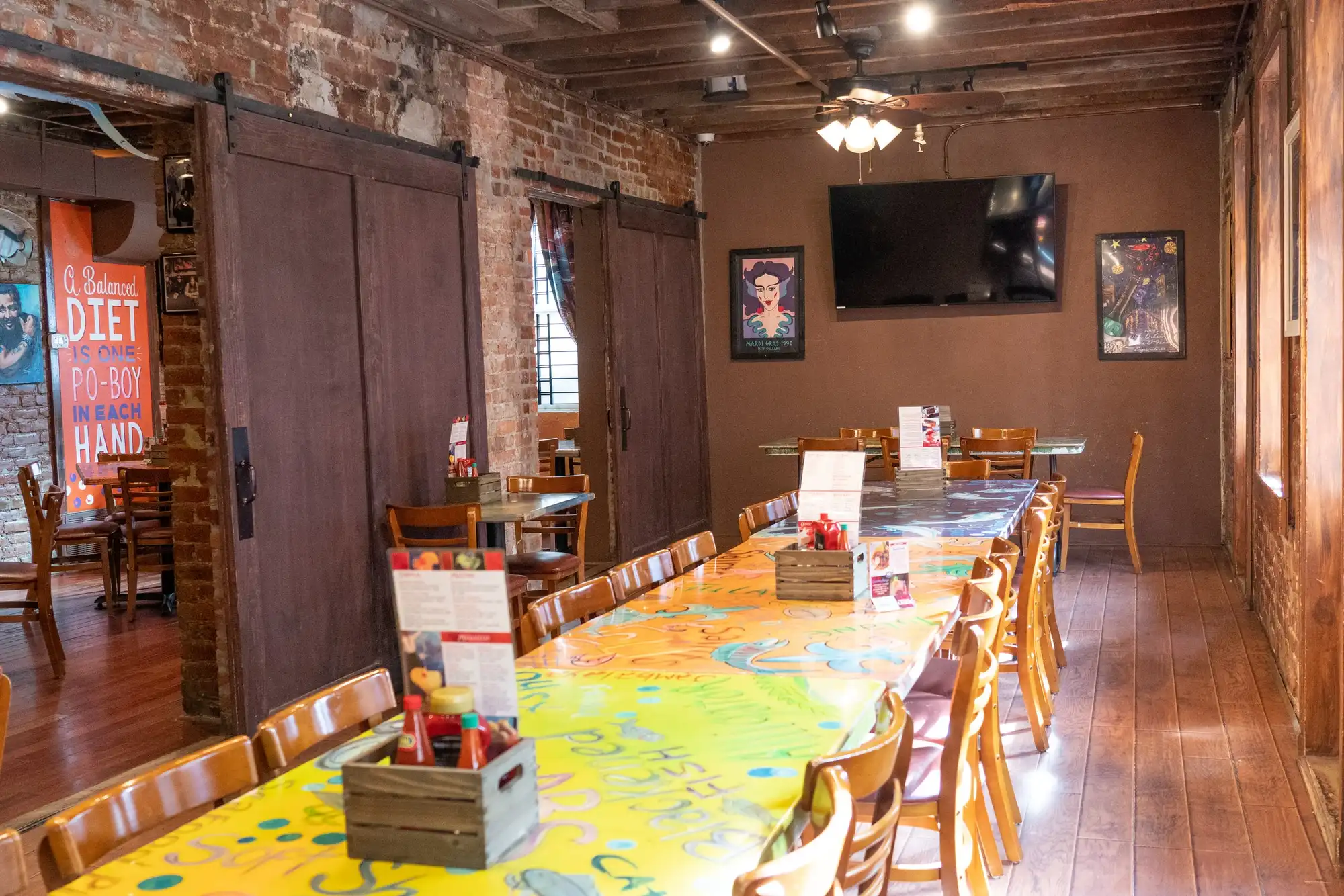 The LaFourche Room: one long painted table between brick walls and sliding barn doors
