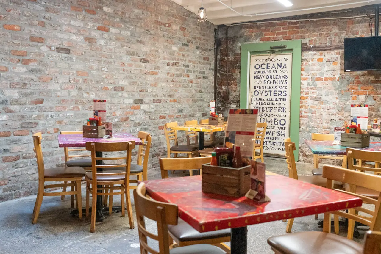 Colorful painted tables against exposed brick in Oceana Grill’s dining room