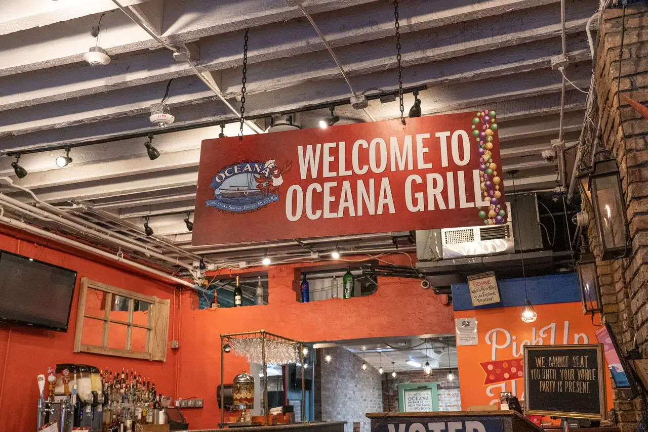 Inside Oceana Grill: a “Welcome to Oceana Grill” sign over the bar and dining room