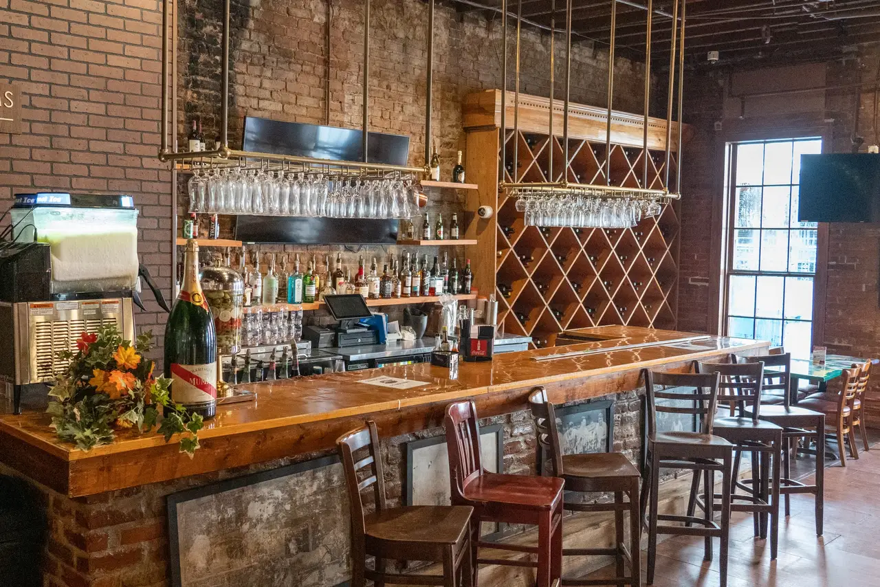 The Presidential Room’s private bar, with hanging glassware and a wall of wine