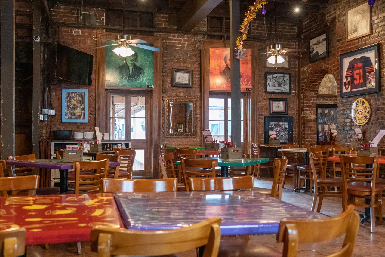 Dining tables beneath a brick arch and wine rack in the Presidential Room