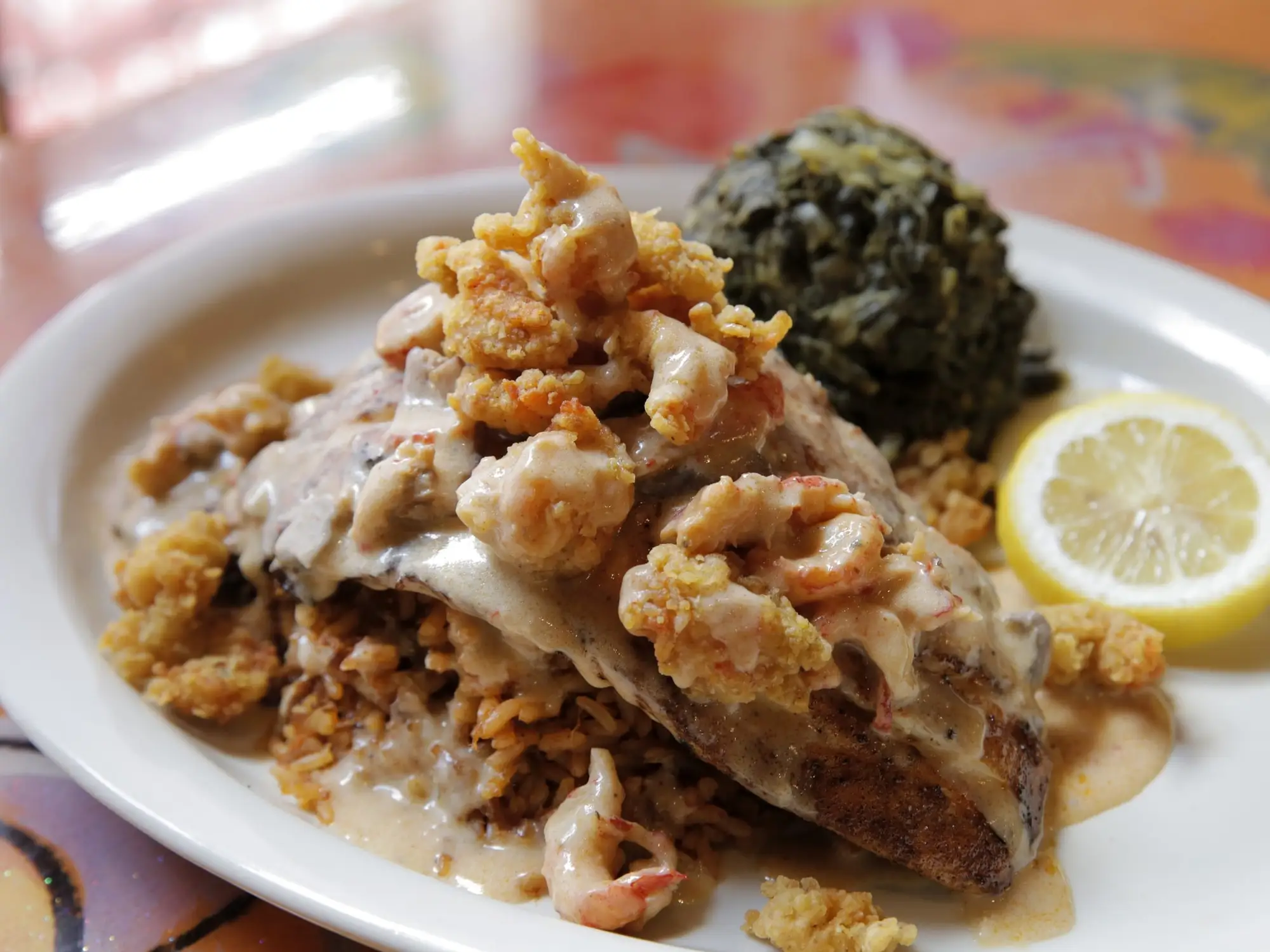 Blackened redfish topped with a crawfish and crab cream sauce, with greens and lemon