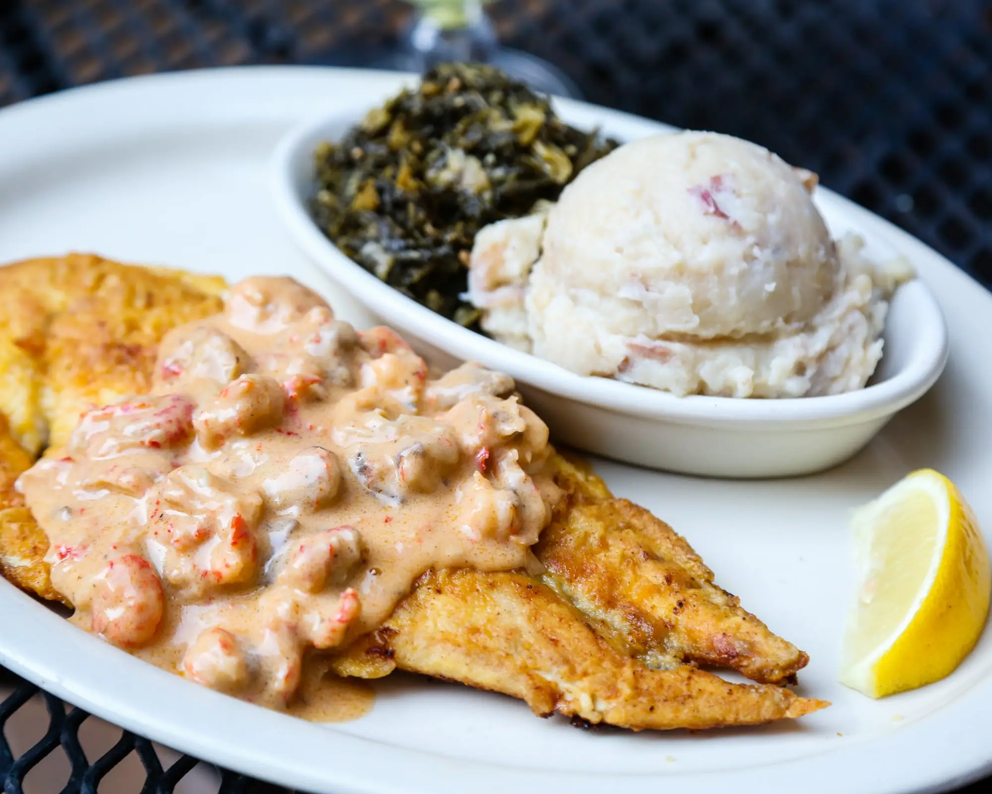Redfish Oceana: pan-sautéed redfish under crawfish mushroom cream sauce, with garlic mashed potatoes and greens