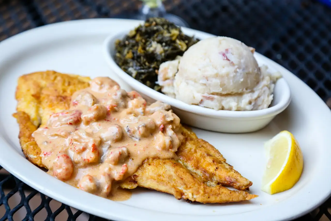 Redfish Oceana: pan-sautéed redfish under crawfish mushroom cream sauce, with garlic mashed potatoes and greens