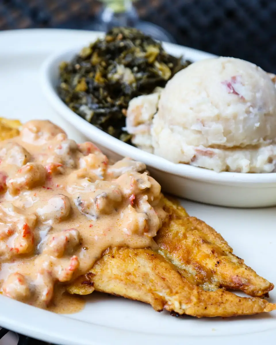 Redfish Oceana: pan-sautéed redfish under crawfish mushroom cream sauce, with garlic mashed potatoes and greens