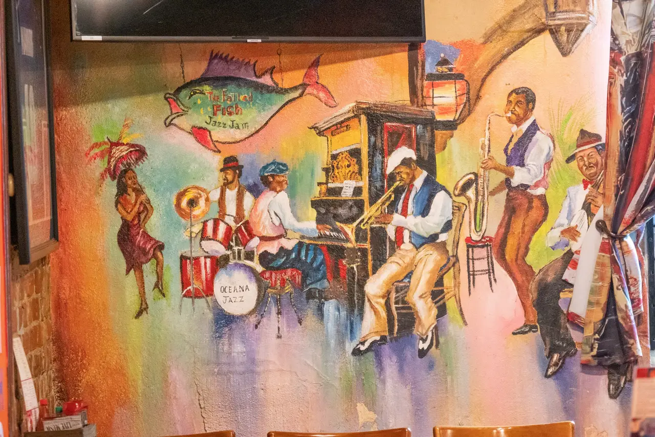 A painted mural of a New Orleans brass band in the Tchoupitoulas Room